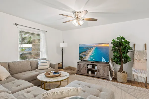 a living room with furniture a chandelier and a flat screen tv
