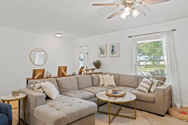 a living room with furniture a chandelier and a window