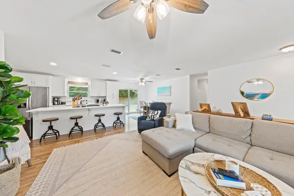 a living room with furniture kitchen view and a potted plant