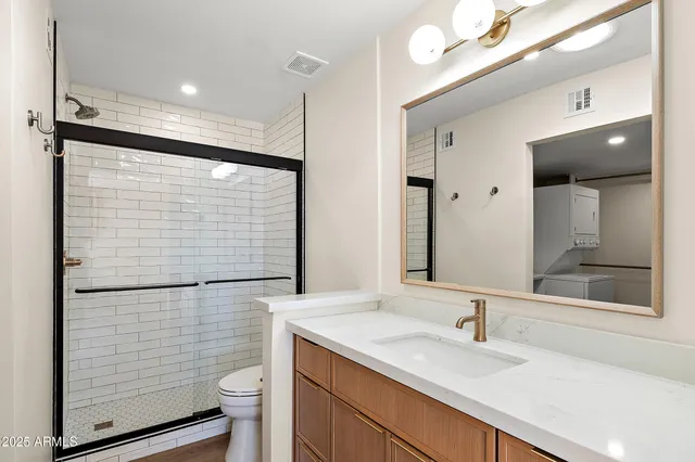 a bathroom with a granite countertop sink toilet and shower