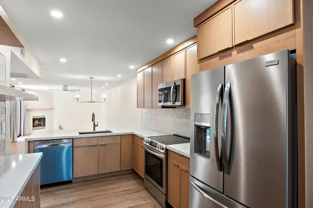 a kitchen with stainless steel appliances a refrigerator sink and cabinets