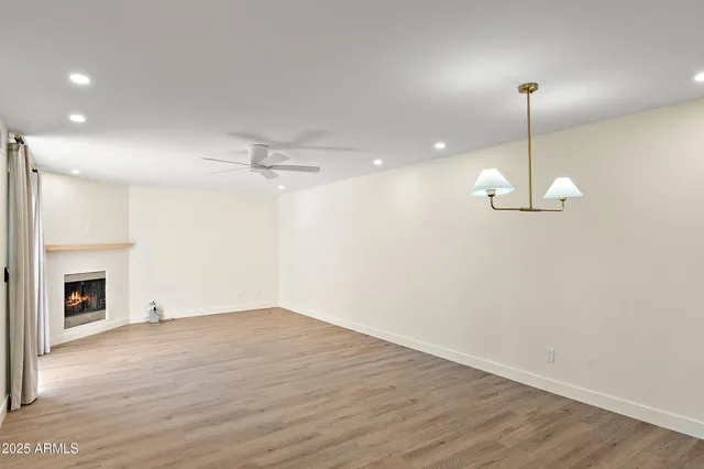 a view of a room with wooden floor fireplace and window