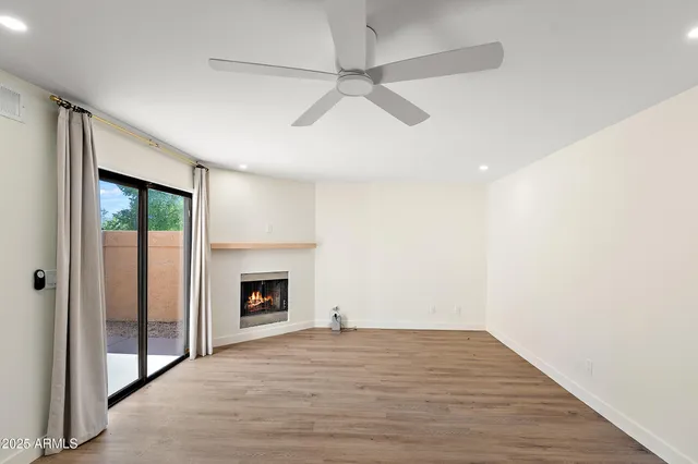 a view of an empty room with a fireplace and a window