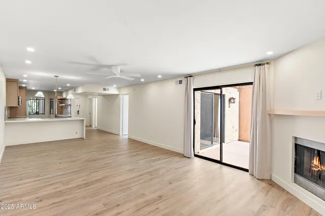 a view of an empty room with a fireplace and a window