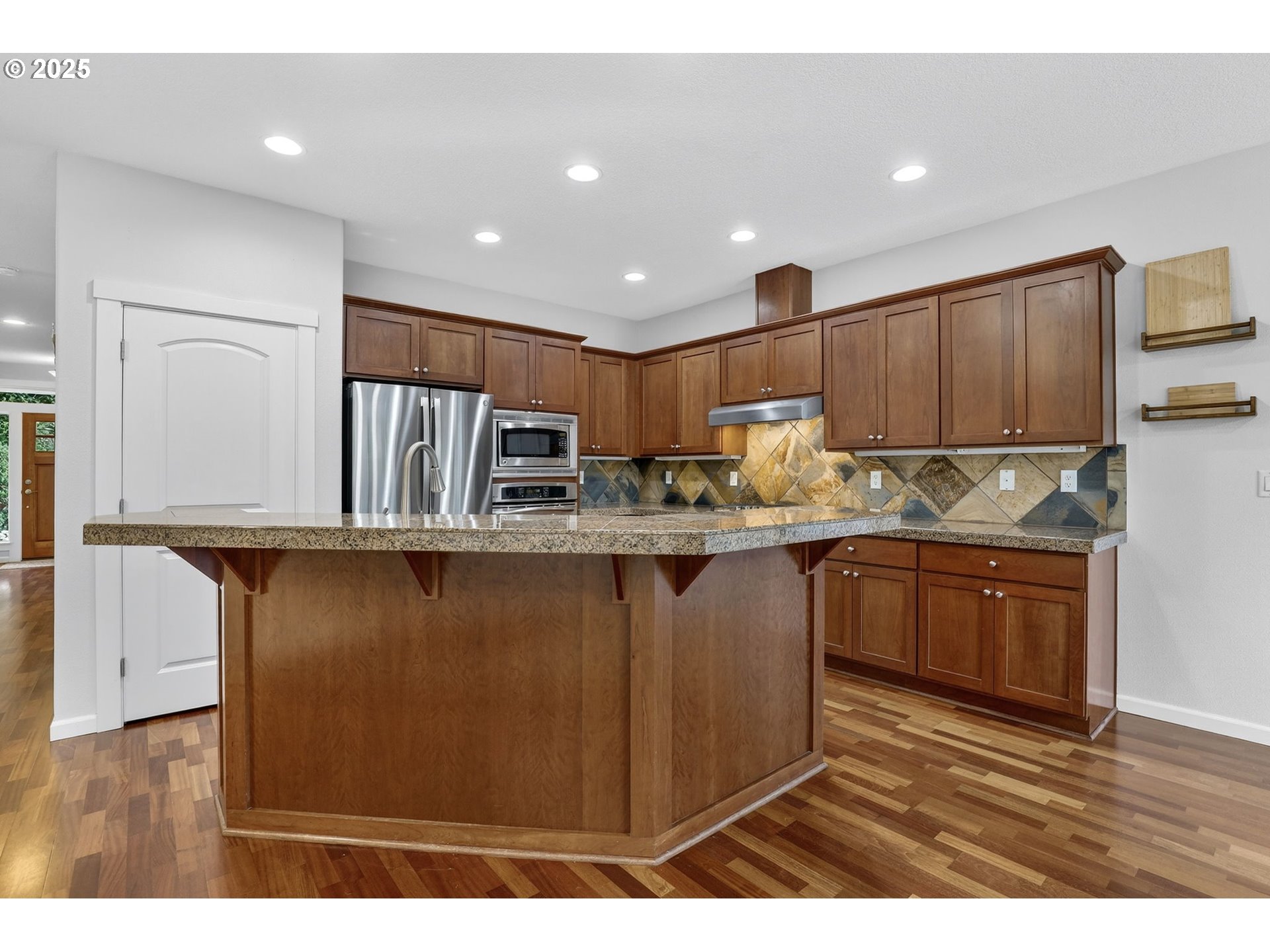 13140 Southwest Madison Court Beaverton, OR 97008 - Photo 15 of 48 a kitchen with stainless steel appliances granite countertop a refrigerator a stove a sink and a oven with wooden floor