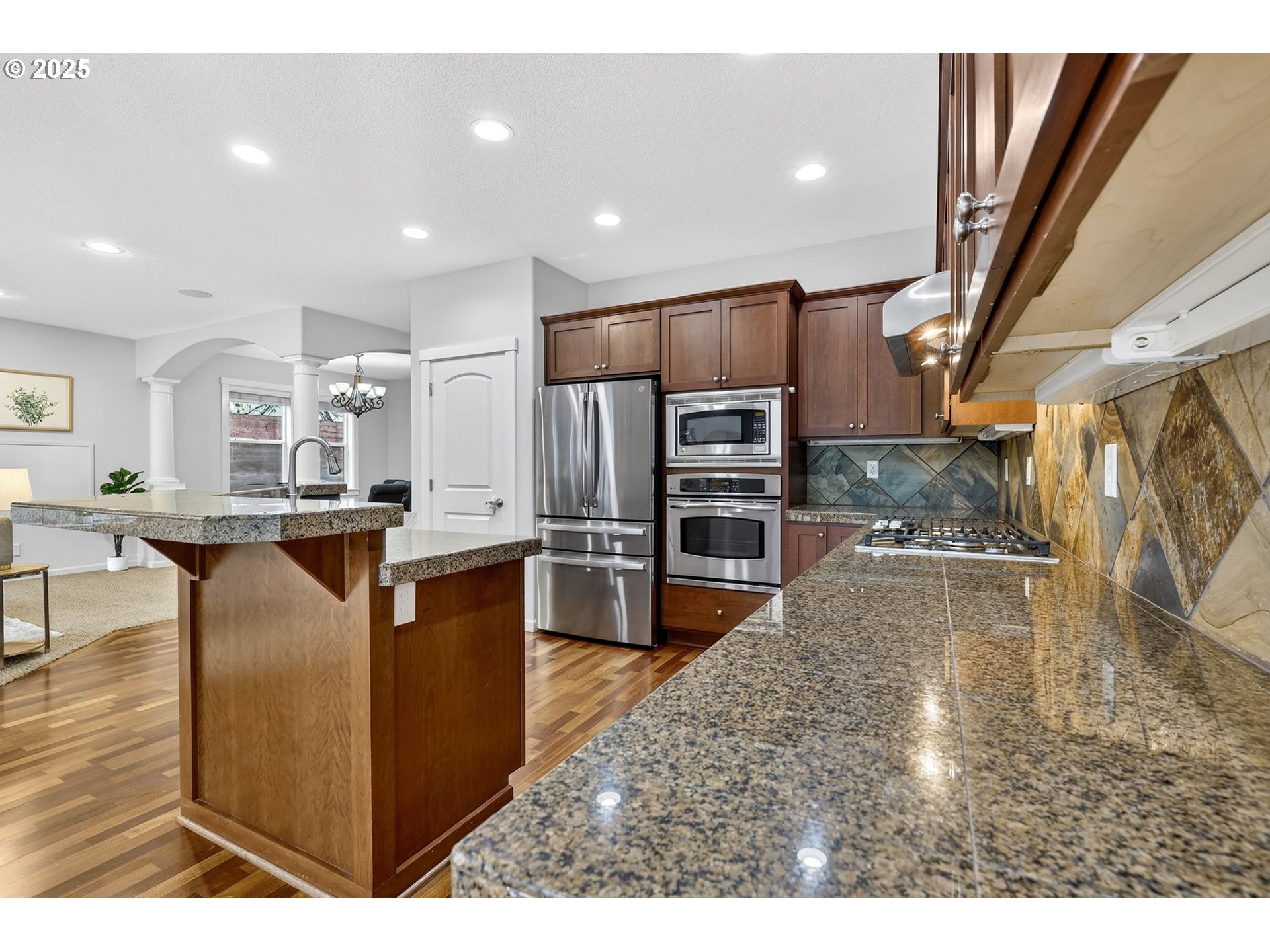 13140 Southwest Madison Court Beaverton, OR 97008 - Photo 16 of 48 a kitchen with stainless steel appliances kitchen island granite countertop a refrigerator and a stove top oven