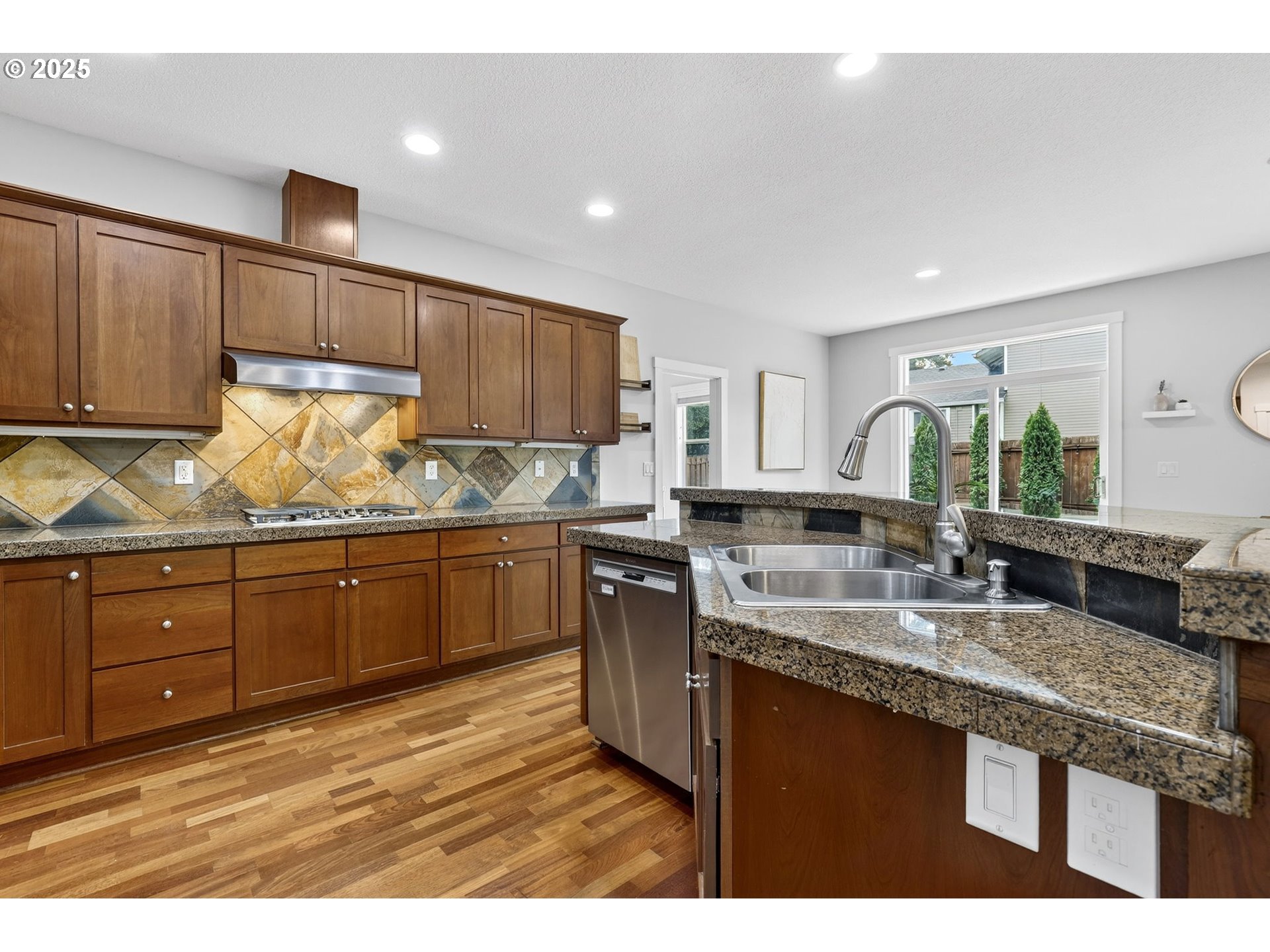 13140 Southwest Madison Court Beaverton, OR 97008 - Photo 19 of 48 a kitchen with granite countertop a sink dishwasher stove and cabinets