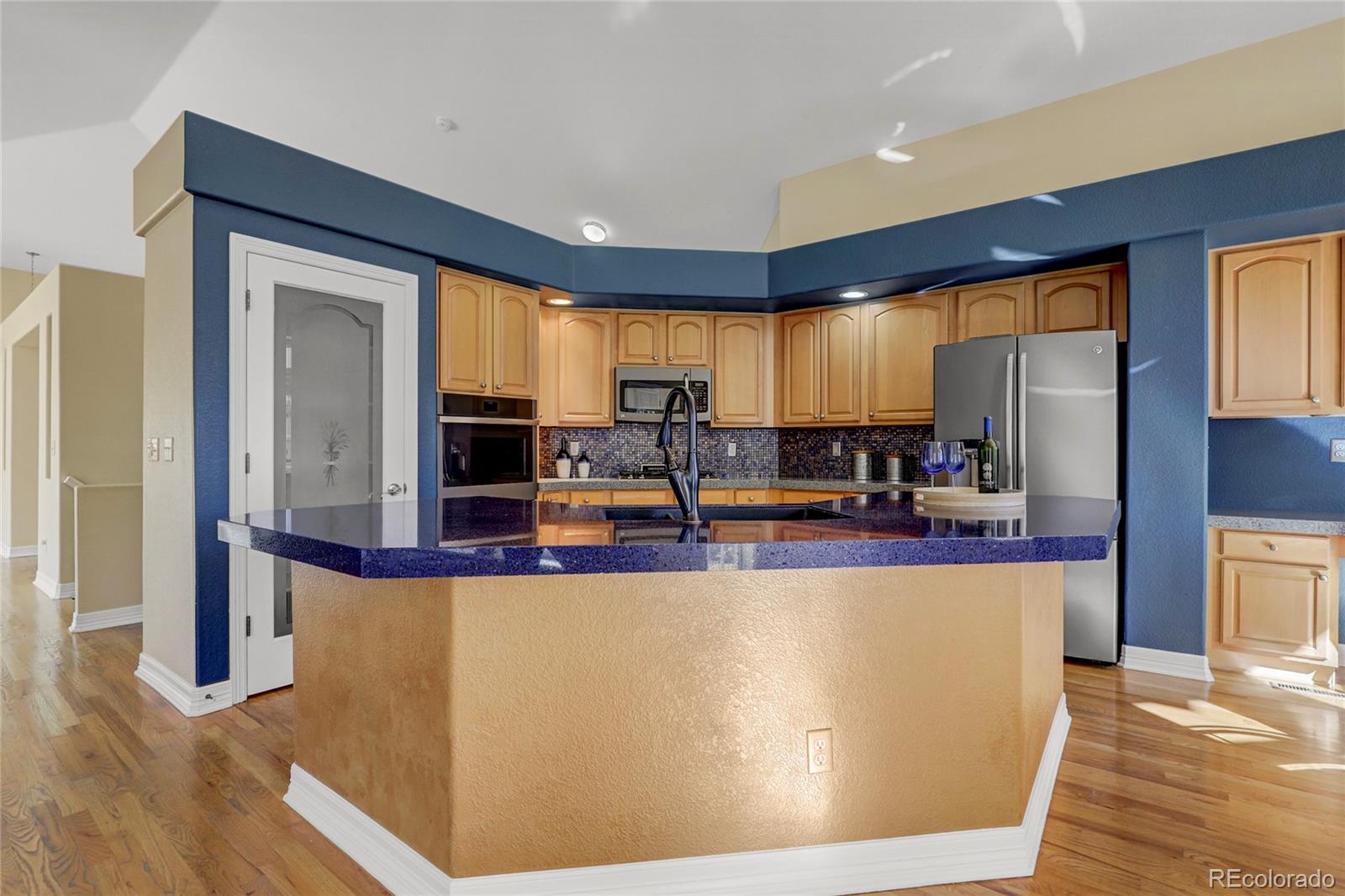 13810 Muirfield Circle Broomfield, CO 80023 - Photo 13 of 45 a view of a kitchen with kitchen island a large window cabinets a sink and stainless steel appliances