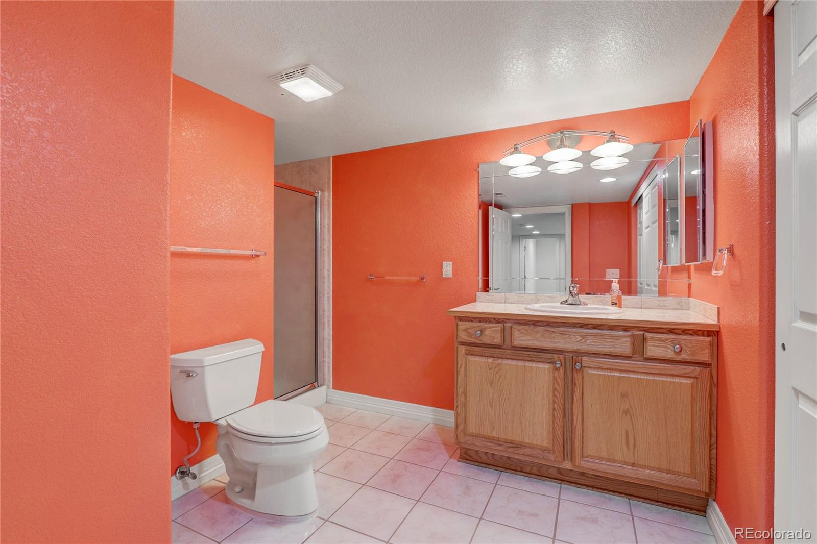 13810 Muirfield Circle Broomfield, CO 80023 - Photo 40 of 45 a bathroom with a toilet a sink and mirror