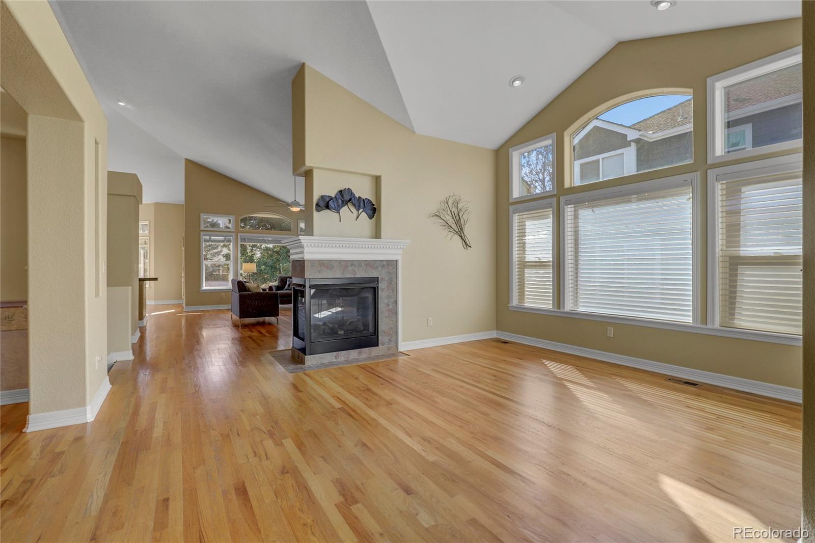 13810 Muirfield Circle Broomfield, CO 80023 - Photo 8 of 45 a view of empty room with fireplace and wooden floor