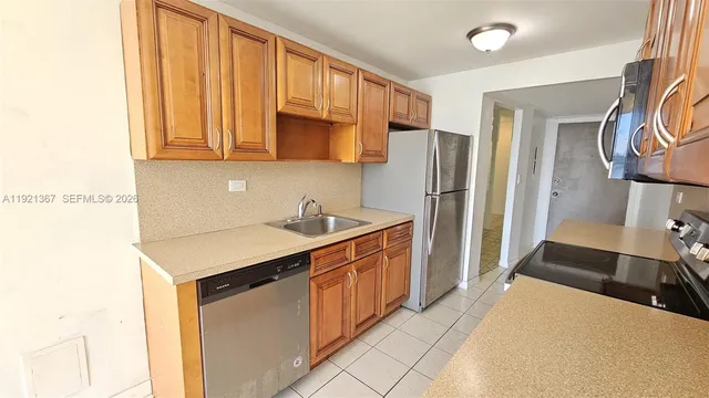 a kitchen with a sink a stove top oven and cabinetry