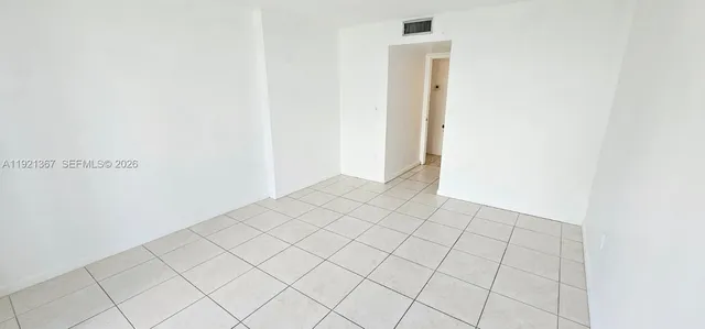 a view of an empty room with a floor to ceiling window and an empty room