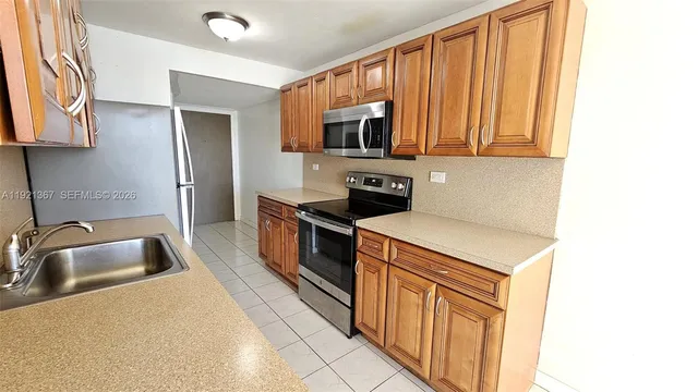a kitchen with stainless steel appliances granite countertop a sink and a refrigerator