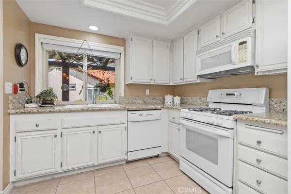 a kitchen with white cabinets and white appliances