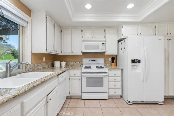 a kitchen with white cabinets and white appliances