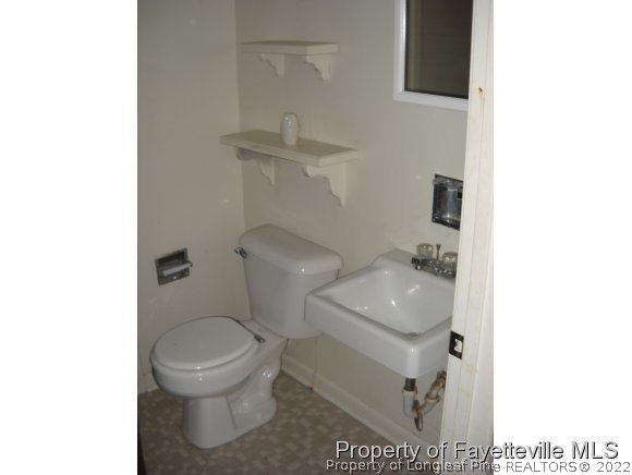438 Lansdowne Road Fayetteville, NC 28314 - Photo 10 of 14 a white toilet sitting next to a bathroom sink
