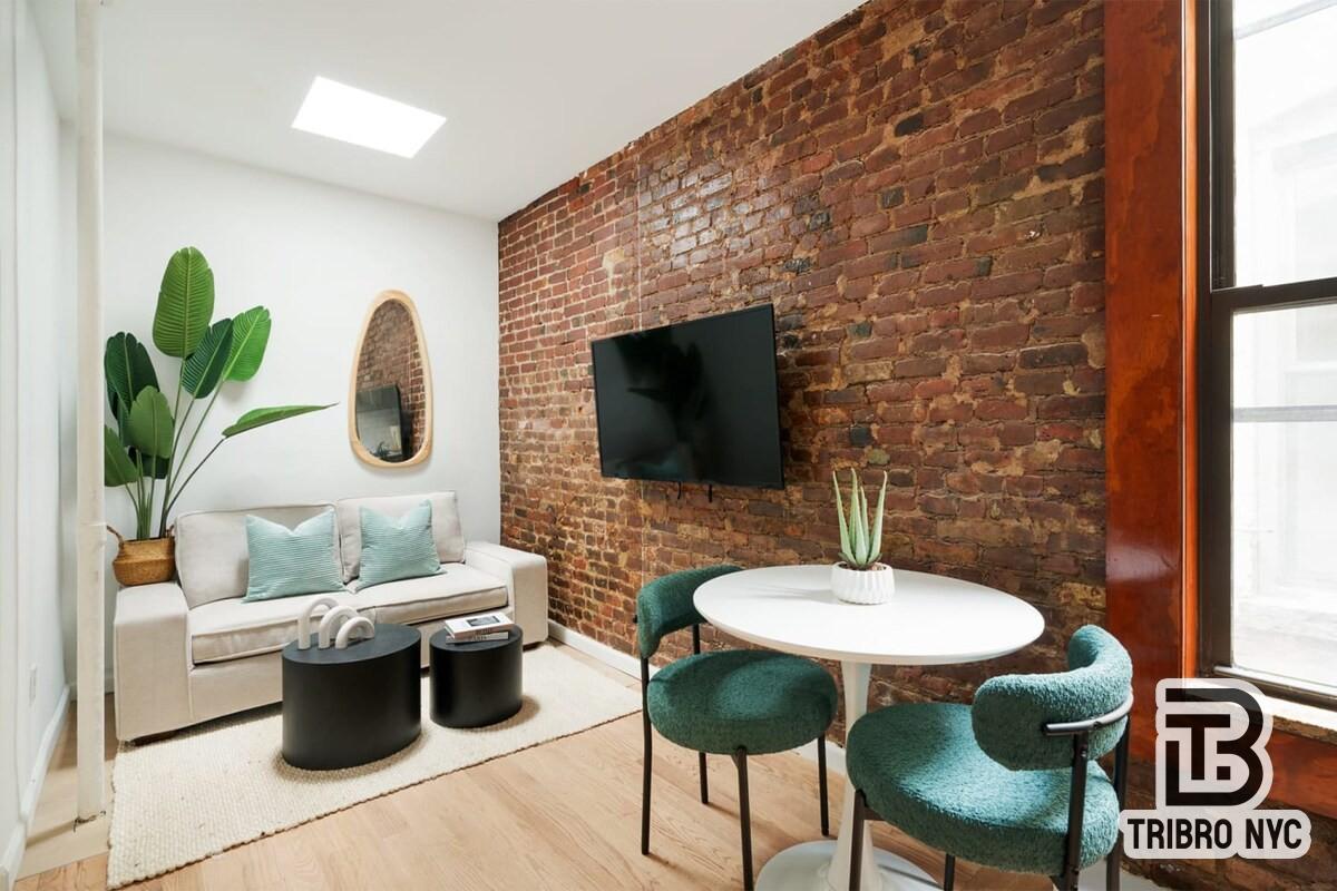 47 Market Street, Unit 3A Manhattan, NY 10002 - Photo 2 of 8 a living room with furniture and a potted plant