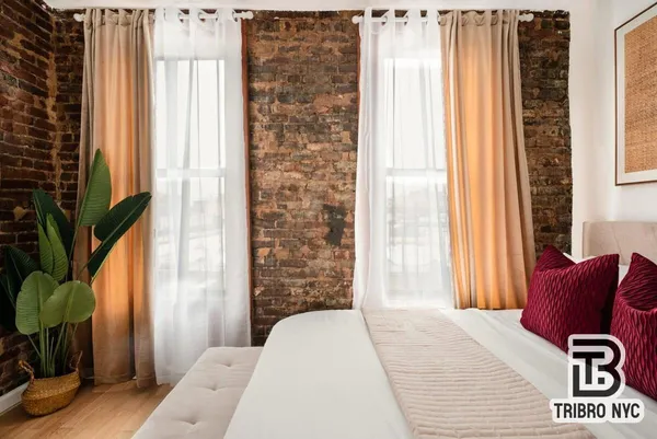 a bedroom with a bed and a chair with the wooden floor