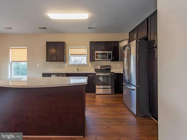 3303 Demirel Way, Unit D Ellicott City, MD 21042 - Photo 2 of 12 a kitchen with stainless steel appliances a refrigerator stove microwave and sink