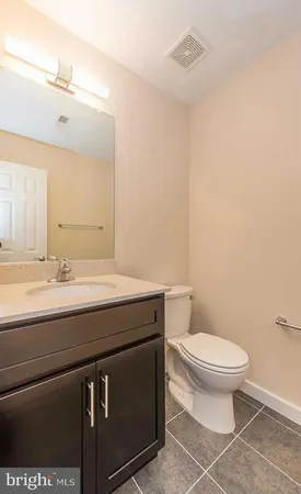 a bathroom with a granite countertop toilet sink and a mirror