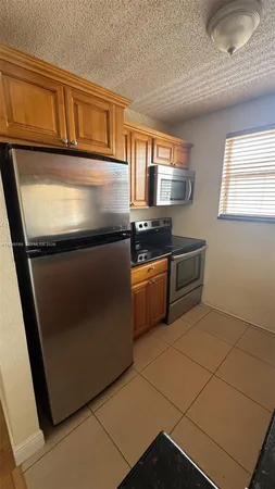 a kitchen with granite countertop a refrigerator and a sink