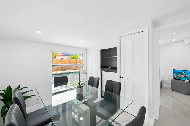 a living room with furniture a flat screen tv and a floor to ceiling window
