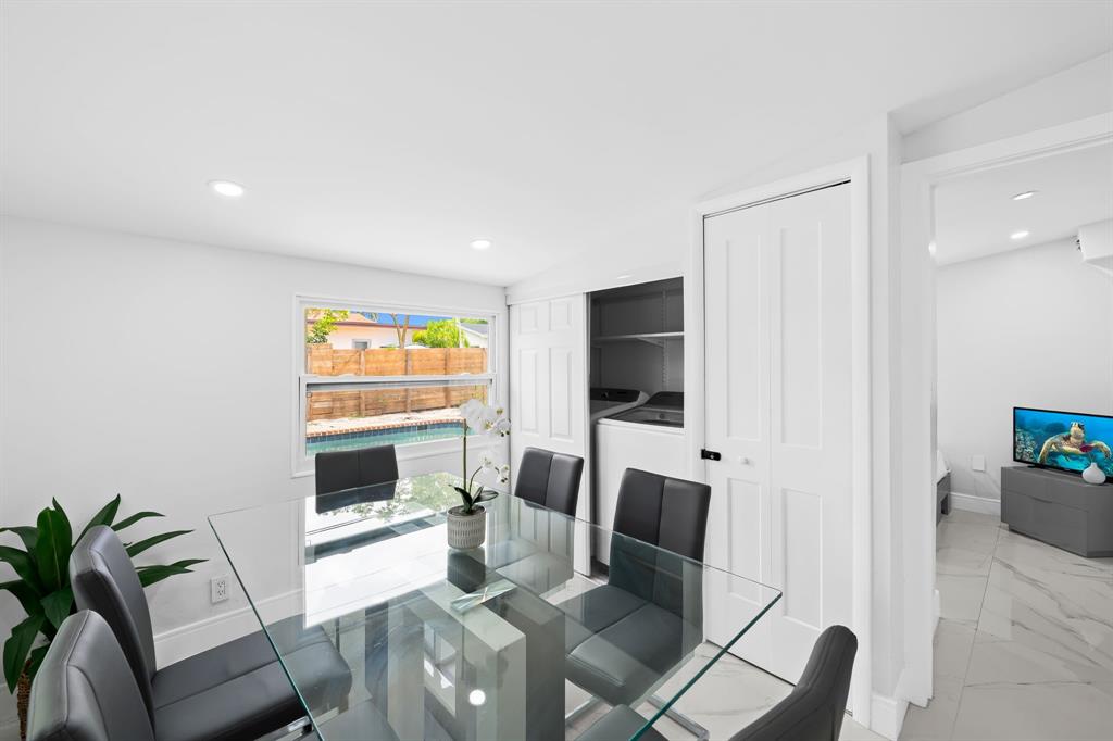 865 Northeast 23rd Terrace Pompano Beach, FL 33062 - Photo 13 of 33 a living room with furniture a flat screen tv and a floor to ceiling window