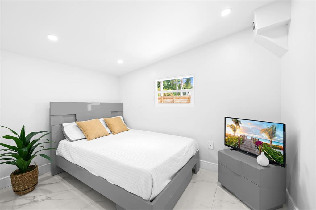 865 Northeast 23rd Terrace Pompano Beach, FL 33062 - Photo 14 of 33 a bedroom with a bed and a painting on the wall