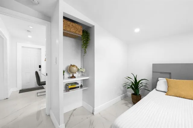 a bedroom with a bed and a potted plant
