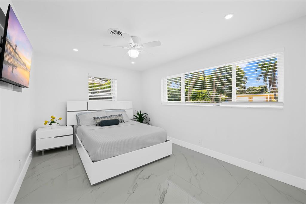 865 Northeast 23rd Terrace Pompano Beach, FL 33062 - Photo 22 of 33 a bedroom with a bed and a flat screen tv