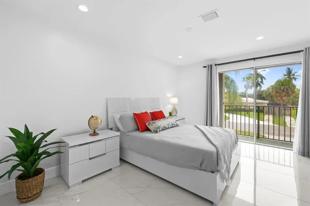 a bedroom with a large bed and a potted plant