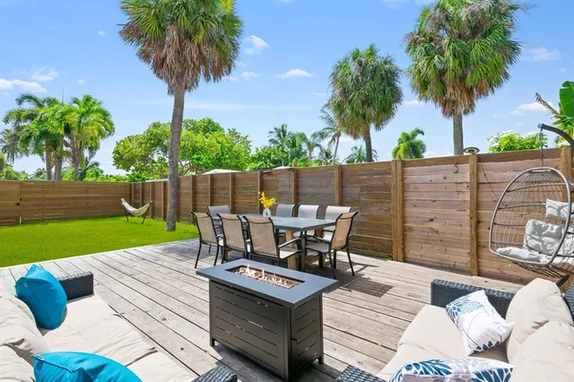 a view of a patio with table and chairs potted plants and palm tree