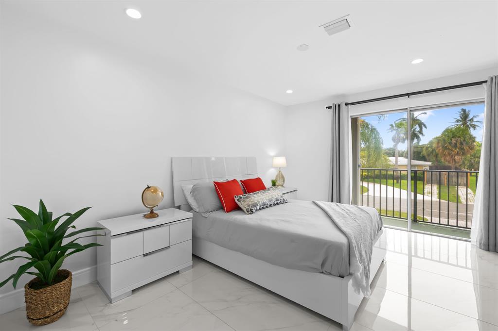 865 Northeast 23rd Terrace Pompano Beach, FL 33062 - Photo 27 of 33 a bedroom with a large bed and a potted plant