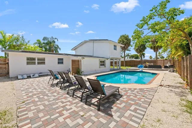 a view of a house with swimming pool and sitting area
