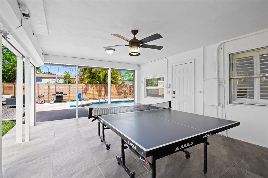 865 Northeast 23rd Terrace Pompano Beach, FL 33062 - Photo 9 of 33 a kitchen with a table chairs and a chandelier