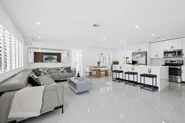 a living room with furniture and kitchen view