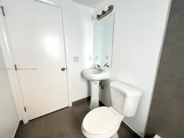 a white toilet sitting next to a bathroom sink