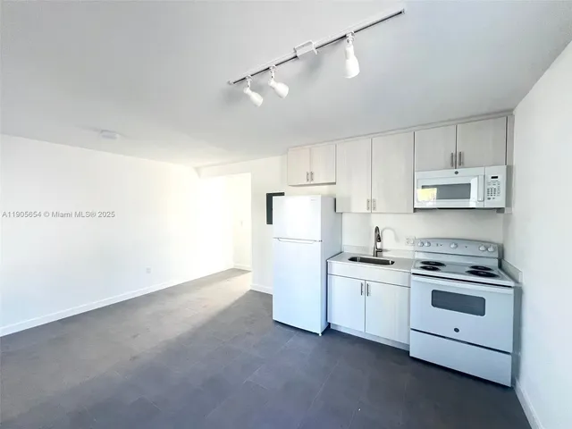 a kitchen with cabinets appliances and a window