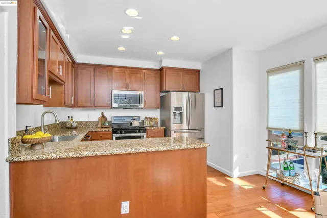 a kitchen with stainless steel appliances granite countertop a refrigerator stove a sink and a microwave