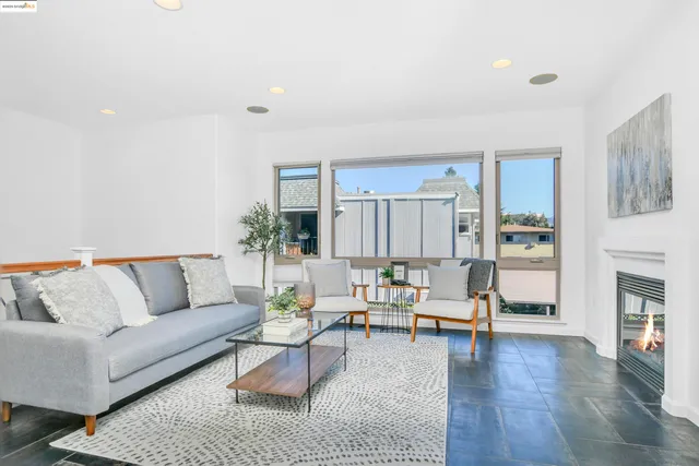 a living room with furniture and a view of kitchen