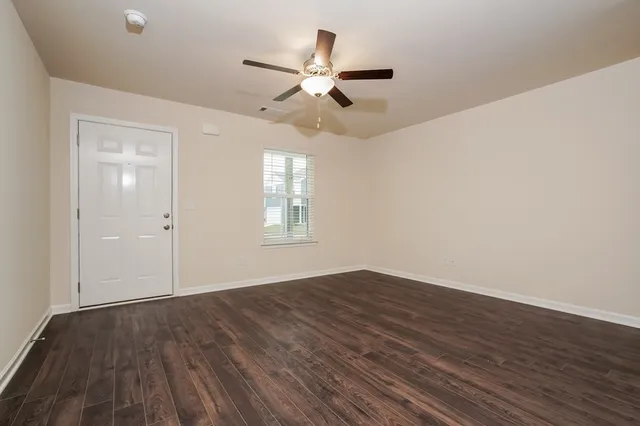 wooden floor in an empty room with a window
