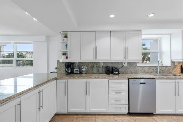 a kitchen with granite countertop a sink and cabinets