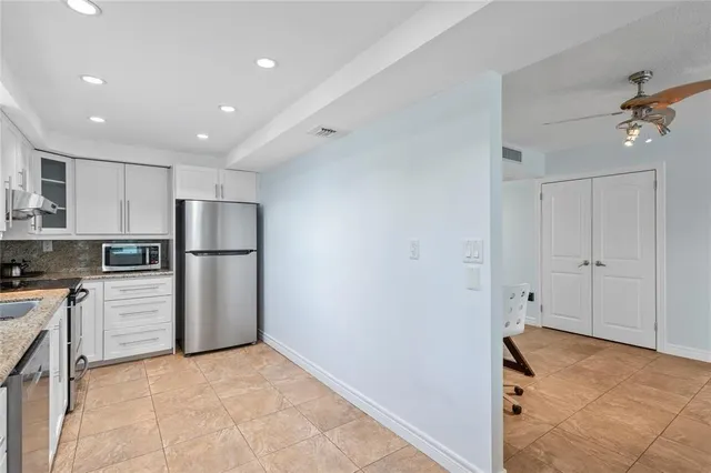 a view of a kitchen with refrigerator and chairs