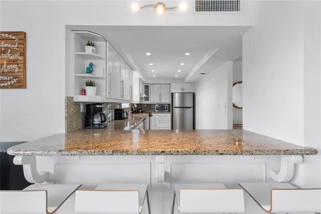 a kitchen with a table chairs and granite counter tops