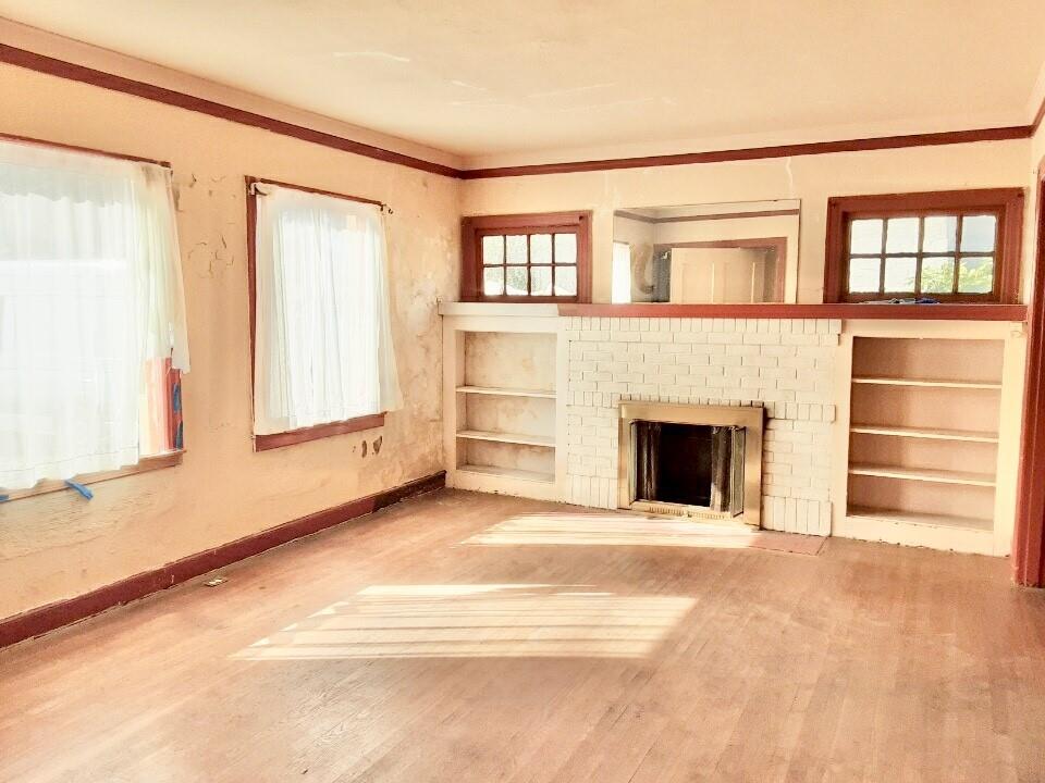 a view of an empty room with a fireplace and a window