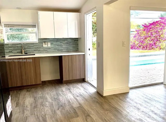 a view of kitchen with granite countertop cabinets and window