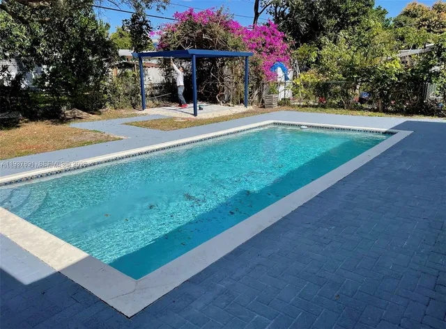 a view of swimming pool with sitting area and furniture