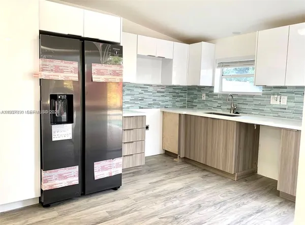 a kitchen with stainless steel appliances granite countertop a refrigerator and a sink
