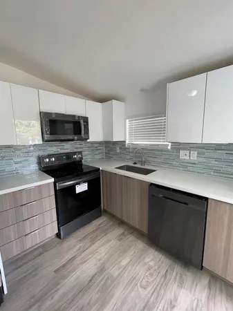 a kitchen with granite countertop a stove top oven and cabinets