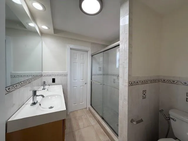 a bathroom with a sink mirror toilet and shower